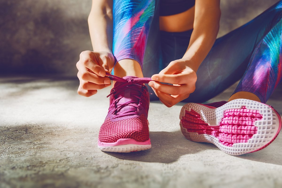 Manos atando los cordones de unas zapatillas deportivas antes de una sesión de entrenamiento con Guim, entrenador personal